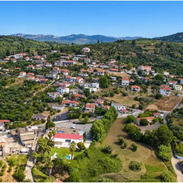 Agios Georgios bei Pyrgos aus der Drohnenperspektive, Ziegeldächer zwischen Olivenhainen und niedrigen Hügeln.
