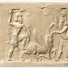 Abrollung eines Rollsiegels: Zwei Helden packen einen geflügelten, menschenköpfigen Stier und stoßen zu.
