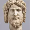 Cabeza de mármol con cabello ondulado y barba, catalogada como «Cabeza de Cristo o de Zeus».