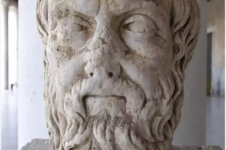 Dem Historiker Herodot zugeschriebener Marmorkopf eines bärtigen, kahlen Mannes auf einem Sockel in der Attalos-Stoa, Athen