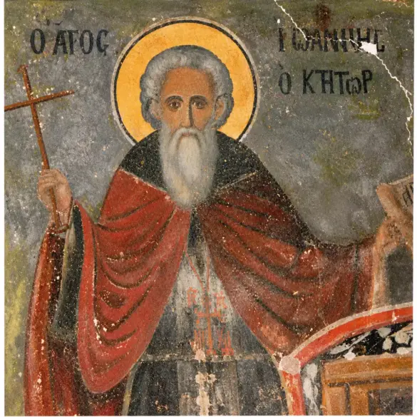 Ο Όσιος Ιωάννης ο Ίβηρας με λευκή γενειάδα, σταυρό και ειλητάριο σε τοιχογραφία της Μονής Ιβήρων.